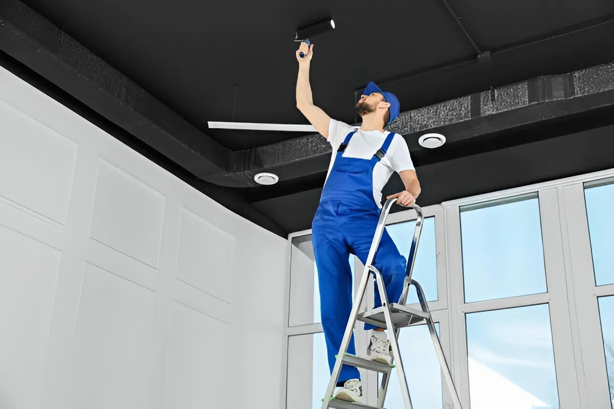 Commercial painter in Bel Air, MD, applying ceiling paint in a commercial space